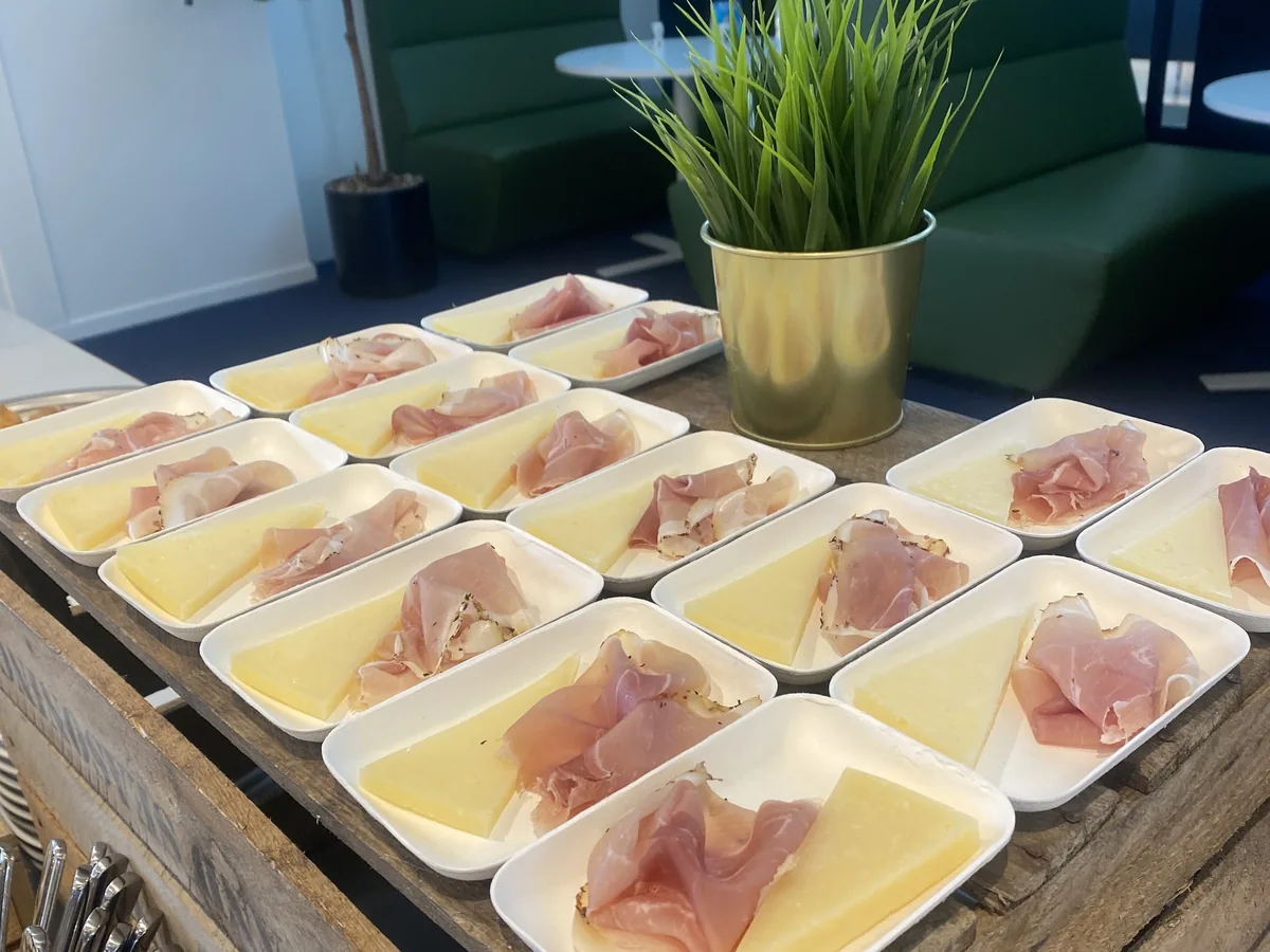 Bordjes met gedroogde ham en meloen, klaargezet op een houten tafel