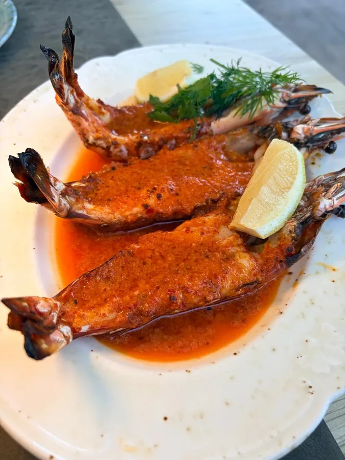 Twee grote gamba's in een rode saus met citroen en dille