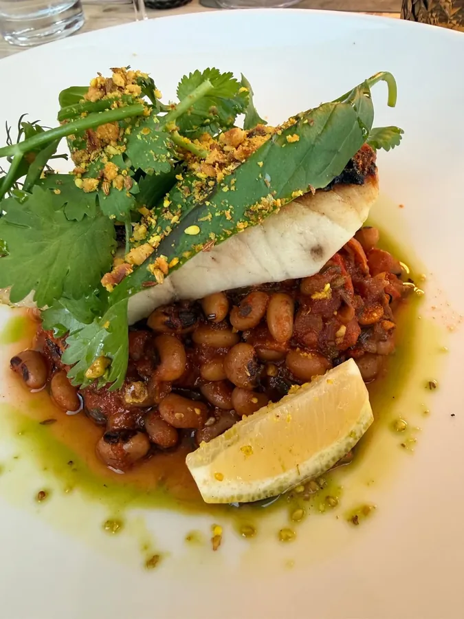Witte visfilet op zwartoogbonen met koriander, pistachekruim en limoen