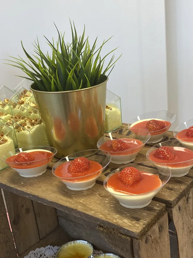 Glaasjes met tomaat en garnaal op een houten buffettafel