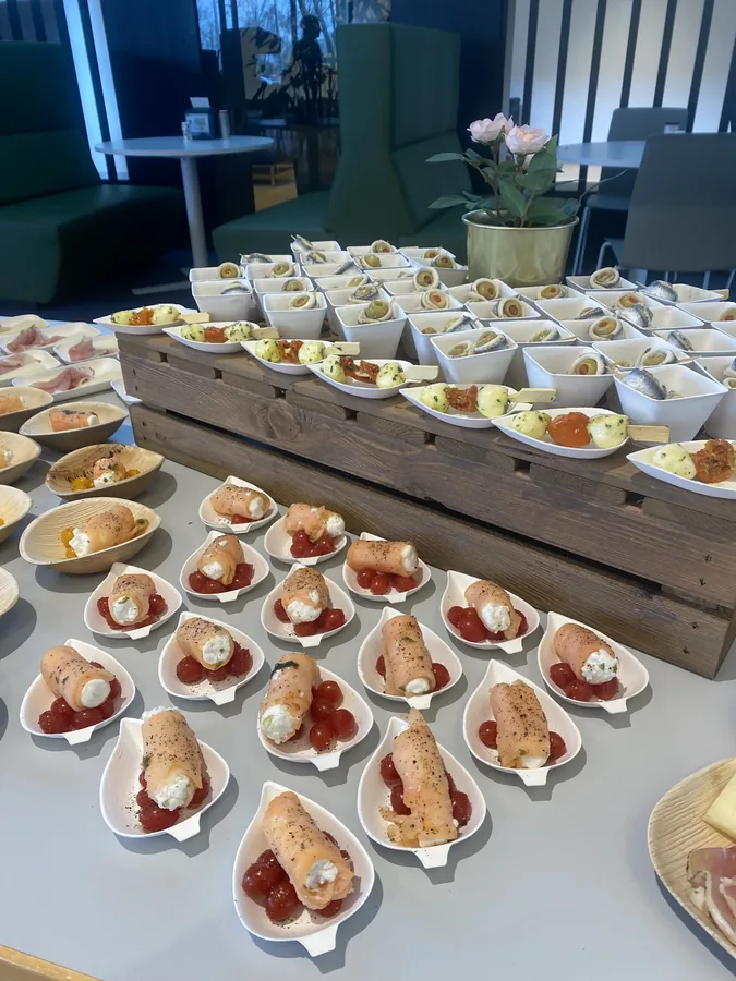Een buffet vol klaargezette hapjes op houten opstellingen