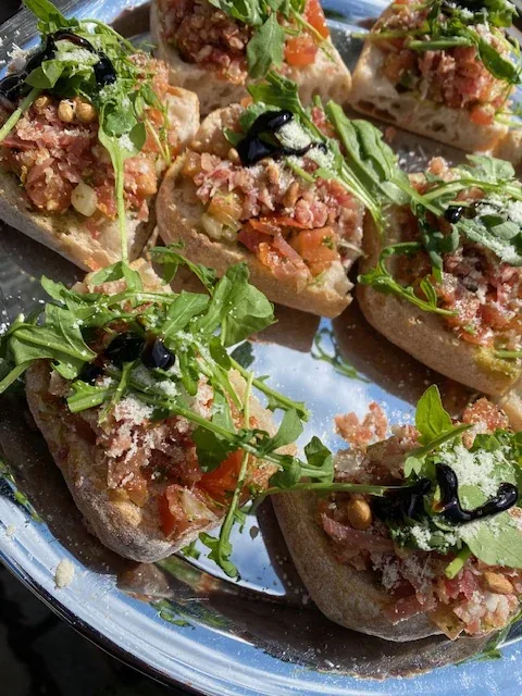 Toastjes met tartaar, tomaat en rucola op een schaal