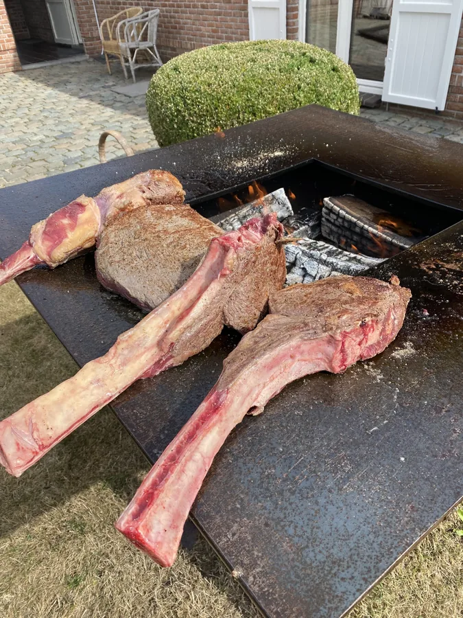 Twee tomahawksteaks op de rand van de vuurschaal