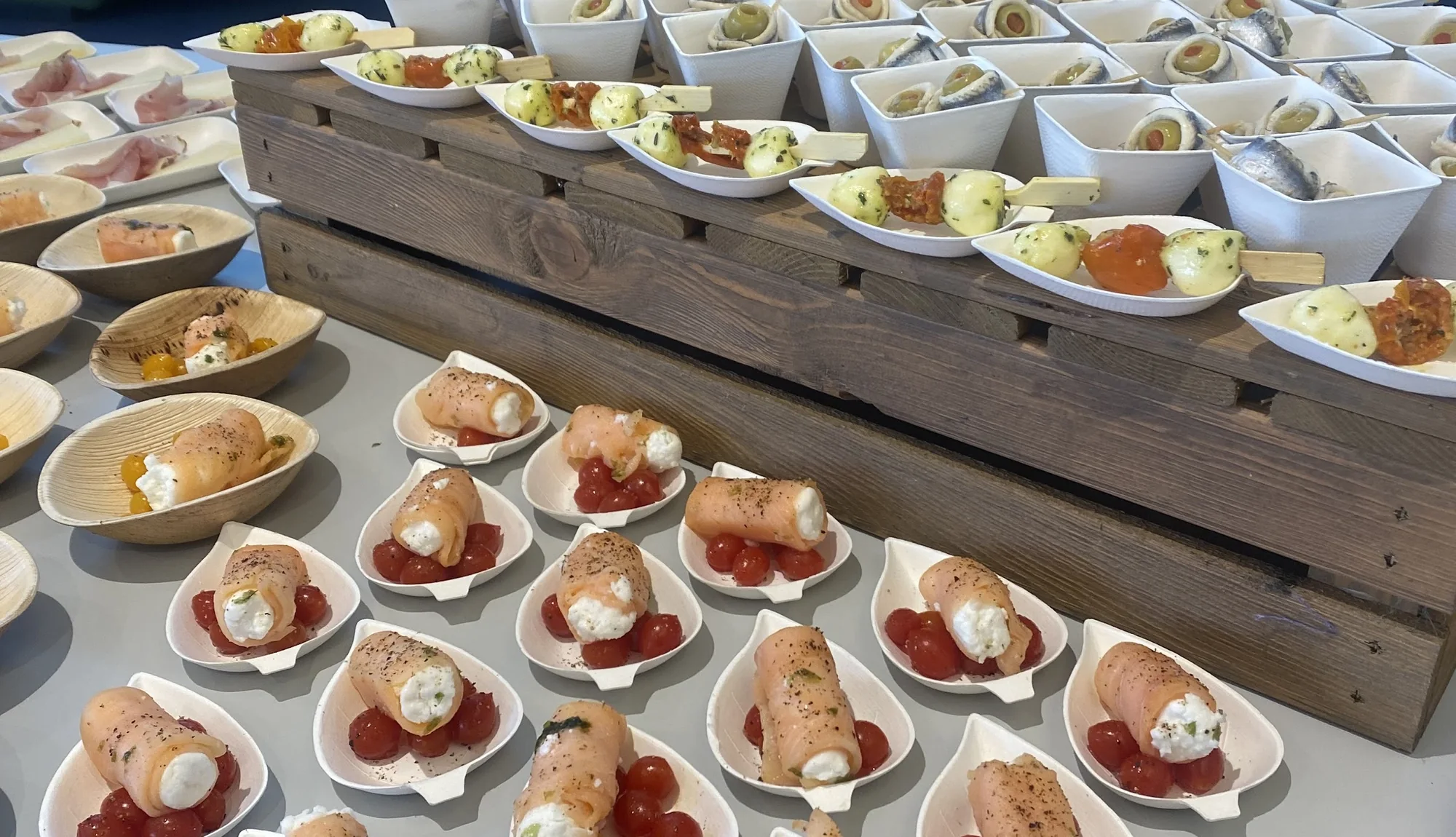 Een buffet vol klaargezette hapjes op houten opstellingen