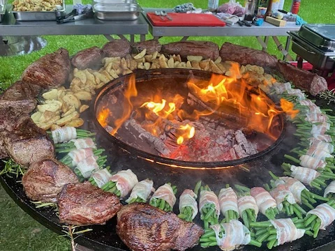 De Ofyr vol met steaks, boontjes in spek en krieltjes, met vuur in het midden
