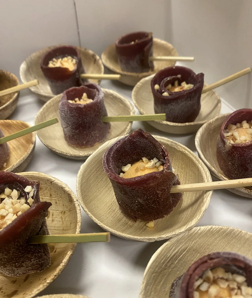 Chocoladecupjes met een romige vulling, op houten schaaltjes met prikkers