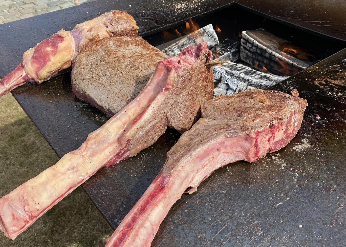 Twee tomahawksteaks op de rand van de vuurschaal